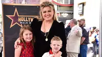 Penyanyi dan pembawa acara talk show Kelly Clarkson bersama anak-anaknya River Rose (kiri), dan Remington (kanan) berpose di atas bintang Hollywood Walk of Fame di Los Angeles, Amerika Serikat, 19 September 2022. Setelah 20 tahun memenangkan musim perdana acara kompetisi menyanyi, Kelly Clarkson akhirnya diakui sebagai bintang di Hollywood Walk of Fame. (Photo by Jordan Strauss/Invision/AP)