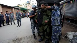 Anggota kepolisian bersiap menjinakkan bom yang ditemukan di sekitar sebuah sekolah di Kathmandu, Nepal, Selasa (20/9). Sebelumnya, bom Kecil telah meledak di luar dua sekolah di ibukota Nepal, Selasa pagi. (REUTERS/Navesh Chitrakar)
