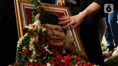 Anggota keluarga dan kerabat memegang foto mantan Menko Bidang Kemaritiman, Rizal Ramli usai proses pemakaman di tempat pemakaman umum (TPU) Jeruk Purut Jakarta, Kamis (4/1/2024). (Liputan6.com/Herman Zakharia)