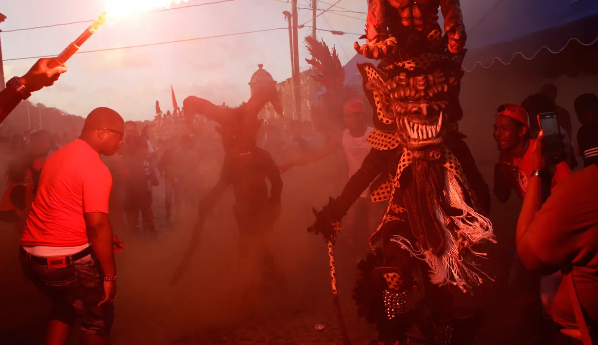 Sejumlah warga merayakan festival Congos and Devils di luar benteng San Jeronimo di Portobelo, Panama (18/3). Festival ini adalah perpaduan budaya Katolik dan keyakinan Afrika yang digelar sejak tahun 1999. (AP Photo/Arnulfo Franco)