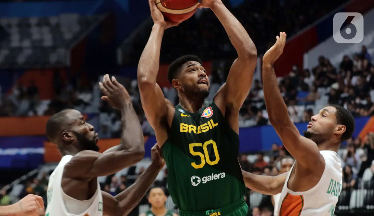 Pemain timnas basket Brasil, Bruno Caboclo berusaha menembus adangan dua pemain Pantai Gading pada penyisihan Grup G FIBA World Cup 2023 di Indonesia Arena, Gelora Bung Karno, Jakarta, Rabu (30/8/2023). (Liputan6.com/Helmi Fithriansyah)