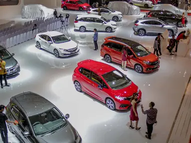 Pengunjung melihat mobil yang dipamerkan saat pembukaan Indonesia International Motor Show (IIMS 2019) di JIExpo Kemayoran, Jakarta, Kamis (25/4). Pameran industri otomotif tersebut berlangsung 25 April - 5 Mei 2019. (Liputan6.com/Faizal Fanani)