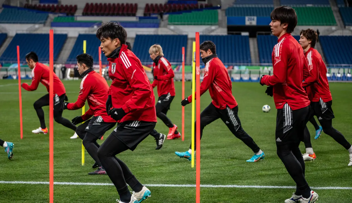 Para pemain Jepang melakukan pemanasan dalam sesi latihan di Stadion Saitama di Saitama (31/1/2022). Jepang akan bertanding melawan Arab Saudi Grup B putaran 3 Kualifikasi Piala Dunia 2022 Zona AFC. (AFP/Philip Fong)