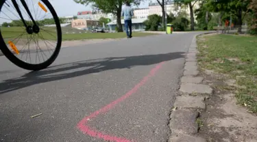 Gambar pada 8 Mei 2019 menunjukkan garis berwarna pink yang diperuntukkan bagi bandar narkotika di aspal Taman Goerlitzer, Berlin. Nantinya, para bandar hanya boleh bertransaksi di dalam zona berupa coretan kotak dengan cat semprot berwarna pink itu saja. (Paul Zinken / dpa / AFP)