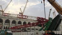 Pekerja dibantu alat berat berusaha mengevakuasi crane yang roboh di Masjidil  Haram, Kota Mekah,  Arab Saudi (9/12/2015). Sebanyak 107 calon jemaah haji meninggal dunia akibat crane jatuh karena cuaca buruk. (AFP PHOTO / STR)