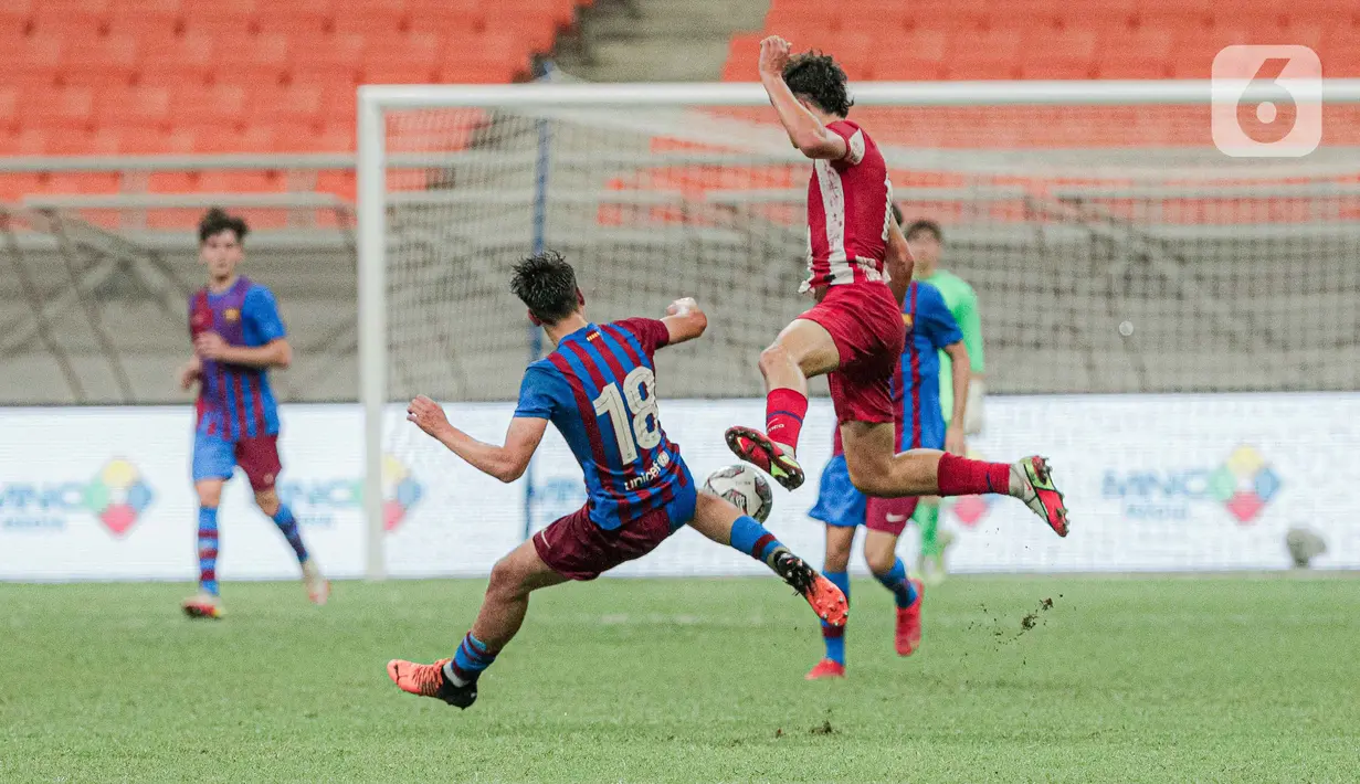 Pemain Barcelona U-18 Marc Guiu Paz (kiri) berebut bola dengan pemain Altetico Madrid U-18 pada pertandingan International Youth Championship (IYC) 2021 di Jakarta International Stadium (JIS), Jakarta, Selasa (19/4/2022). Barcelona U-18 menang 1-0. (Liputan6.com/Faizal Fanani)