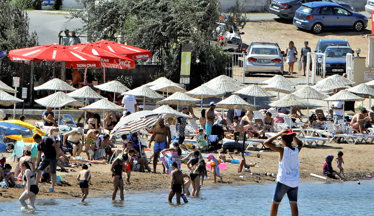 Warga berlibur di sebuah pantai di Distrik Ayvalik, Provinsi Balikesir, Turki, 4 Agustus 2020. Ramainya kunjungan warga Turki ke pantai-pantai selama liburan empat hari Idul Adha pekan lalu memicu kekhawatiran merebaknya kembali pandemi COVID-19 di negara itu. (Xinhua/Osman Orsal)