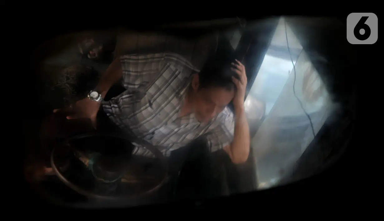 Refleksi Joni (43) dari kaca spion Metromini 53 saat menunggu penumpang di Terminal Kampung Melayu, Jakarta, Selasa (12/11/2019). Joni mengaku pendapatannya saat ini dari hasil menarik paling tinggi hanya Rp 150 ribu per hari. (merdeka.com/Iqbal Nugroho)