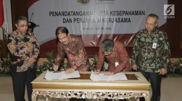Menteri Agraria dan Tata Ruang/Badan Pertahanan Nasional (ATR/BPN) Sofyan A. Djalil (kedua kiri) bersama Direktur Utama PT Pegadaian (Persero) Sunarso (kedua kanan) menandatangani kerjasama di Jakarta, Rabu (18/4). (Liputan6.com/Angga Yuniar)