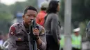 Polisi beristirahat sambil memegang senjata di depan Istana Negara, Jakarta, Jumat (4/11). Ribuan aparat gabungan disiagakan saat massa melakukan aksi menuntut penegakan hukum kasus dugaan penistaan agama. (Liputan6.com/Helmi Fithriansyah)