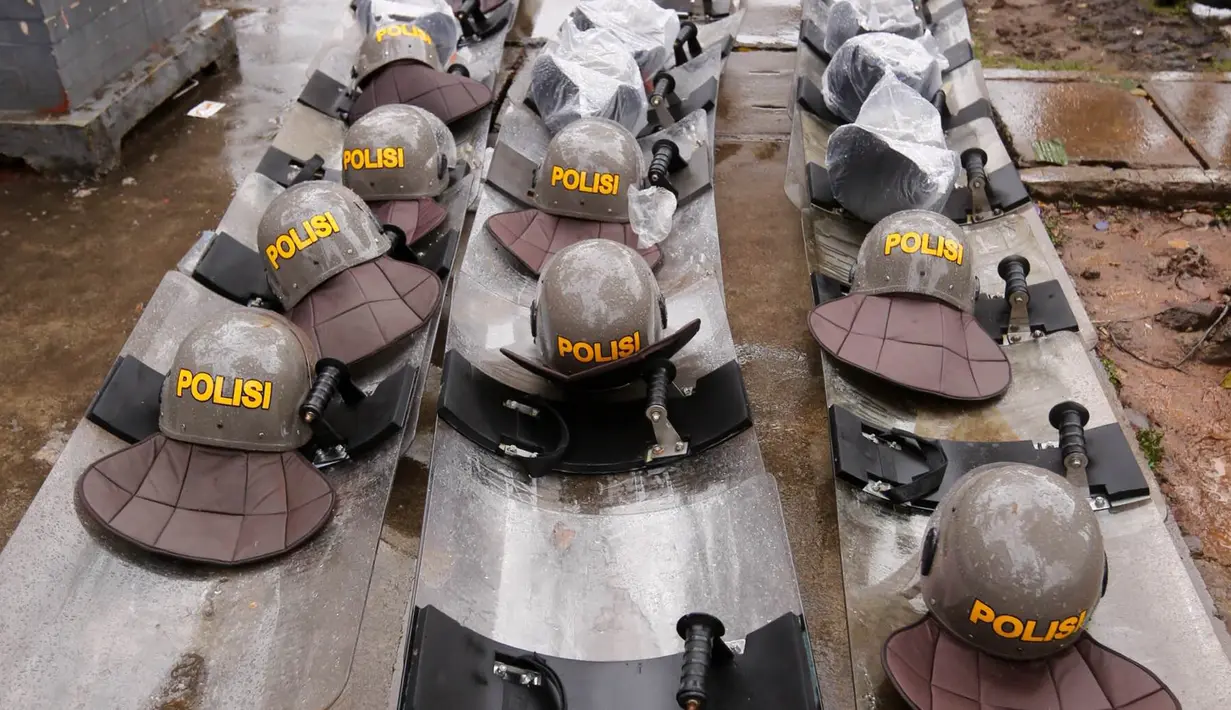 Sejumlah helm dan tameng polisi diletakkan di trotoar kawasan Sarinah, Jakarta Pusat, Jumat (2/12). Meski aksi damai 2 Desember telah usai, mereka tetap berjaga sampai situasi kondusif. (Liputan6.com/Ferbian Pradolo)