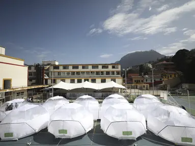Para perancang (kiri) berada di dalam salah satu Unit Isolasi Epidemiologi Portabel mereka, selama presentasi media di Bogota, Selasa (16/2/2021). Sekolah arsitektur Universitas La Salle Kolombia merancang kubah isolasi epidemiologi portabel untuk pasien corona COVID-19. (AP Photo/Fernando Vergara)