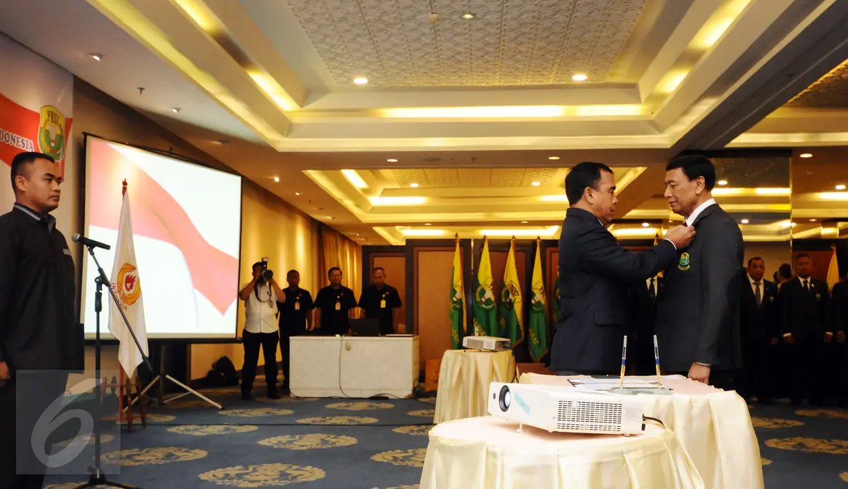 Ketua KONI Pusat, Tono Suratman (kiri) menyematkan pin PBSI kepada Ketua Umum PP PBSI Wiranto saat pelantikan di Jakarta, Kamis (19/1). Wiranto menjabat sebagai Ketua Umum PP PBSI periode 2016-2020. (Liputan6.com/Helmi Fithriansyah)