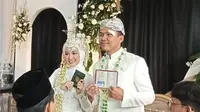 Alnez Rainansantana dan Nazwa Aulia, siswa kelas XII MIPA 3, SMA Negeri 4 Bandung, pemeran pasangan pengantin dalam simulasi pernikahan tengah memperlihatkan buku nikah (dok/achmad yani yustiawan)