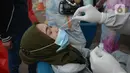 Seorang perempuan menjalani tes usap atau Swab Antigen di Pelabuhan Kali Adem, Jakarta, Kamis (31/12/2020). Pemeriksaan swab antigen kepada wisatawan yang akan liburan Tahun Baru di Kepulauan Seribu dilakukan untuk mencegah penyebaran COVID-19. (merdeka.com/Imam Buhori)