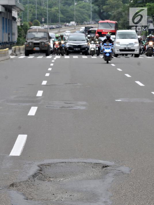 Kondisi jalanan yang berlubang di Jalan Jenderal Sudirman, Jakarta, Senin (11/3). Minimnya perawatan dan pengawasan membuat jalan tersebut berlubang hingga kedalaman 10 sentimeter. (merdeka.com/Iqbal S. Nugroho)