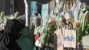 Warga mengambil berbagai sayuran yang digantung pada pagar rumah di Gang Palautan, Cilodong, Depok, Jawa Barat, Jumat (21/1/2022). Berbagi sayuran, beras, dan bumbu masak setiap Jumat ini bentuk solidaritas kepada warga lainnya yang terdampak pandemi COVID-19. (Liputan6.com/Herman Zakharia)