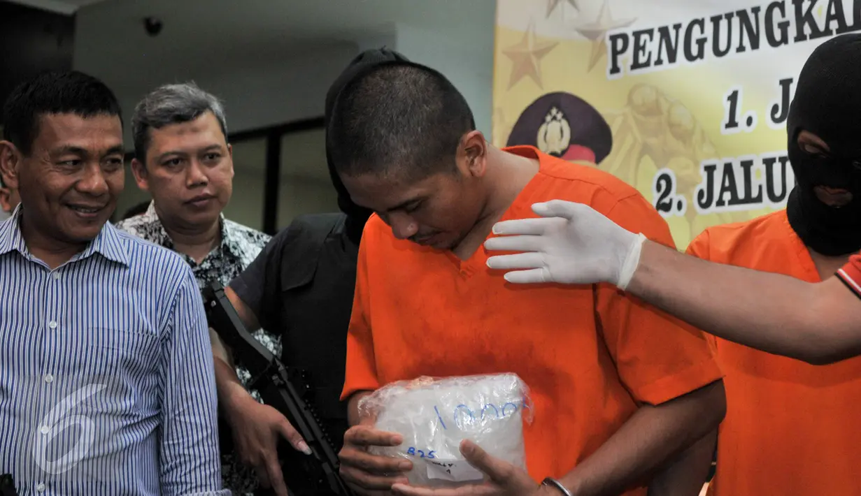 Salah satu tersangka diperlihatkan petugas saat Press Release di kantor Bareskrim Cawang, Jakarta, Selasa (7/3). Bareskrim berhasil mengungkap kasus peredaran narkotika jaringan internasional Malaysia-Indonesia. (Liputan6.com/Yoppy Renato)