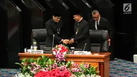 Gubernur dan Wakil Gubernur DKI Jakarta Anies Baswedan (tengah) dan Sandiaga Uno (kiri) bersalaman dalam rapat istimewa bersama DPRD Provinsi DKI Jakarta, Jumat (22/6). Pemprov DKI mengangkat tema 'Adil, Maju, Bahagia'. (Liputan6.com/Immanuel Antonius)