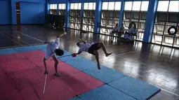 Dua siswa bertarung menggunakan pedang selama berlatih Krabi Krabong di sekolah Thonburee Woratapeepalarak, Thonburi, Bangkok (8/7/2019). Krabi Krabong merupakan seni bela diri Thailand yang dipersenjatai pisau dan perisai kayu yang terabaikan. (AFP Photo/Lillian Suwanrumpha)