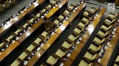 Seorang anggota DPR menghadiri rapat paripurna Masa Sidang I Periode 2019-2020 di antara bangku yang tak terisi di Kompleks Parlemen, Senayan, Jakarta, Kamis (22/8/2019). Rapat yang membahas RUU APBN Tahun 2020 beserta nota keuangannya itu hanya dihadiri 55 orang. (Liputan6.com/Johan Tallo)