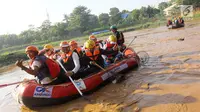 Menteri BUMN Rini M Soemarno membersihkan sampah Sungai Ciliwung dengan naik perahu karet, Jakarta, Minggu (08/4). Rini juga memberikan bantuan 5 perahu karet senilai 120 juta agar masyarakat peduli akan lingkungan sekitar. (Liputan6.com/Fery Pradolo)