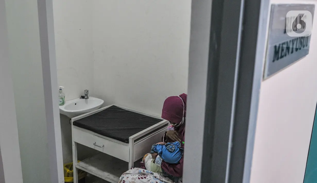 Seorang ibu menyusui anaknya di ruang laktasi saat menunggu antrean imunisasi di Puskesmas Kecamatan Jatinegara, Jakarta, Kamis (26/11/2020). Imunisasi bertjuan mempertahankan tingkat kekebalan optimal sekaligus mencegah terjadinya stunting pada anak. (merdeka.com/Iqbal S. Nugroho)