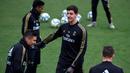 Kiper Real Madrid, Thibaut Courtois (tengah) dan gelandang Casemiro (kiri) berbincang saat menghadiri sesi latihan tim di fasilitas olahraga Real Madrid City di Madrid (17/12/2019). Real Madrid akan bertanding melawan Barcelona dalam laga El Clasico di Nou Camp. (AFP/Javier Soriano)