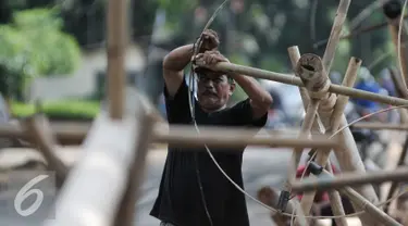 Pedagang mengikat bambu di bagian pohon pinang yang akan digunakan untuk perlombaan 17 Agustus nanti, Jakarta, Selasa (9/8). Jelang HUT RI ke-71, pedagang pohon pinang mulai ramai. (Liputan6.com/Yoppy Renato)