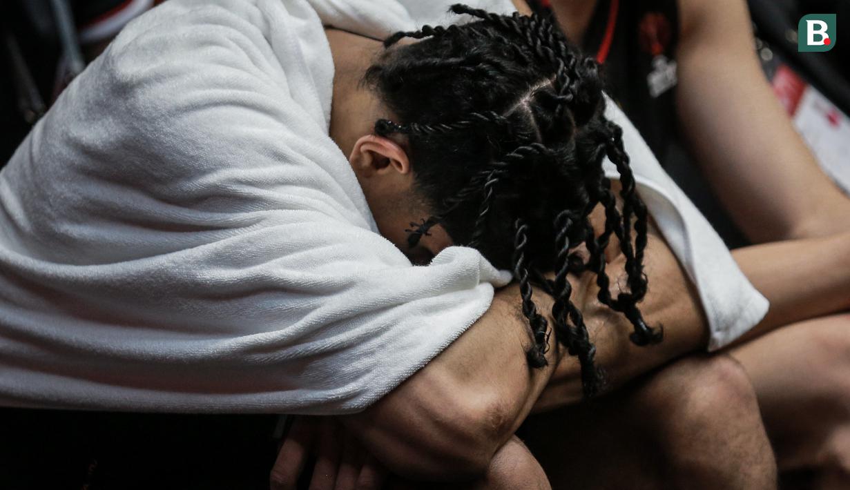 Pemain Timnas Basket Indonesia, Derrick Michael Xzavierro tertunduk di bangku cadangan saat laga playoff perempat final FIBA Asia Cup 2022 antara Timnas Basket China melawan Timnas Basket Indonesia di Istora Senayan, Jakarta, Senin (18/07/2022). (Bola.com/Bagaskara Lazuardi)