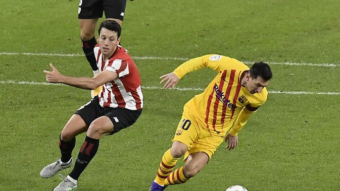 Lionel Messi melewati Mikel Vesga dari Athletic Bilbao pada pertandingan Liga Spanyol antara Athletic Bilbao dan Barcelona di stadion San Mames di Bilbao, Spanyol, Rabu, 6 Januari 2021. (Foto AP / Alvaro Barrientos)