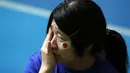 Salah satu warga Jepang di Tokyo menangis usai menyaksikan Keisuke Honda dkk dikalahkan Kolombia 1-4 di laga penutup penyisihan Piala dunia 2014 Grup C, (25/6/2014). (REUTERS/Issei Kato)