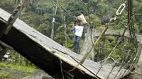 Warga melewati jembatan gantung bersejarah yang ambruk akibat putus tali di Batu Busuak, Padang, Sumbar. (Antara)