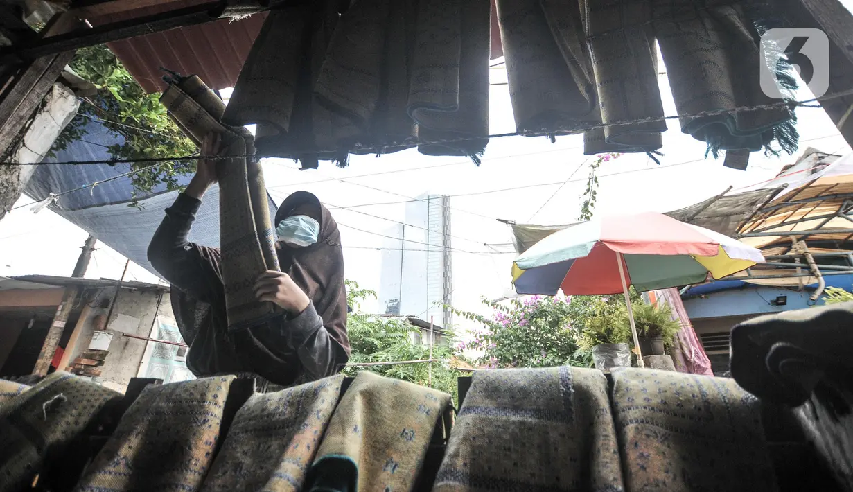Fitri (40) menyelesaikan jasa sablon sajadah di Amang Sablon, Kebon Melati, Jakarta Pusat, Kamis (7/4/2022). Industri rumahan tersebut mengalami peningkatan sebesar 50 persen di bulan Ramadhan 1443 H jika dibandingkan bulan biasanya. (merdeka.com/Iqbal S. Nugroho)