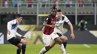 Gelandang AC Milan, Soualiho Meite membawa bola dari kawalan bek Atalanta, Berat Djimsiti pada pertandingan lanjutan Liga Serie A Italia di Stadion San Siro, Minggu (24/1/2021). Meski kalah, hasil Liga Italia ini tetap membuat AC Milan berada di puncak klasemen. (AP Photo/Antonio Calanni)