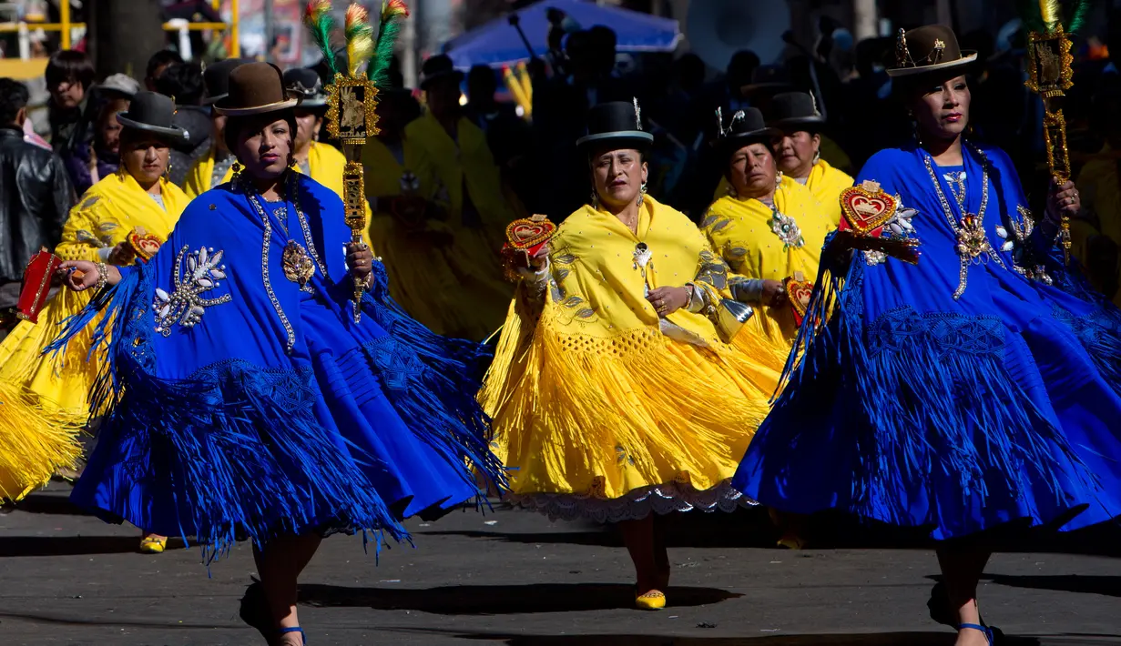 Sejumlah wanita mengenakan kostum menari dalam pawai "Morenada" di La Paz, Bolivia (26/5). Ribuan penari berkumpul melakukan pawai sebagai ucapan terima kasih mereka kepada para dewa. (AP/Juan Karita)