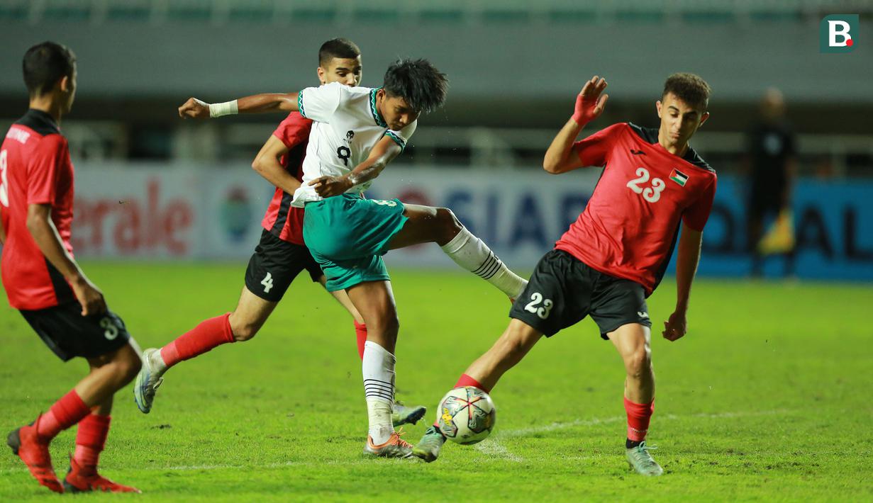 <p>Pemain Timnas Indonesia U-17, Arkhan Kaka melepaskan tendangan yang berusaha diblok pemain Palestina, Baraa Rabei pada laga Grup B Kualifikasi Piala Asia U-17 2023 antara Timnas Indonesia menghadapi Palestina di Stadion Pakansari, Bogor, Jumat (7/10/2022). (Bola.com/M Iqbal Ichsan)</p>