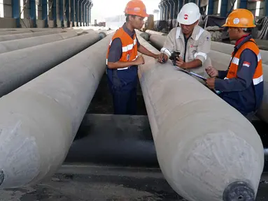 Pekerja menyelesaikan tahap akhir pembuatan precast tiang pancang beton di PT Waskita Beton Precast Plant Prambon, Sidoarjo, Jawa Timur, Kamis (21/11/2019). Plant Prambon memproduksi spun pile, pci girder dan ccsp bagi kebutuhan proyek Jalan Tol Trans Jawa. (Liputan6.com/HO/Eko)