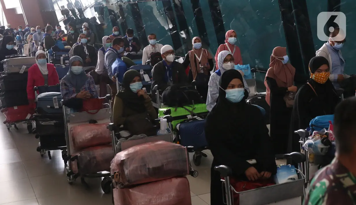Antrean rombongan jemaah umrah yang tiba di Bandara Soekarno Hatta, Tangerang, Selasa (29/12/2020). Rombongan jemaah umrah yang baru tiba di Indonesia tersebut diarahkan untuk melakukan karantina di tempat yang telah disediakan oleh pemerintah. (Liputan6.com/Angga Yuniar)