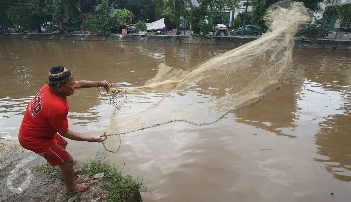 Warga memancing ikan di bantaran Sungai Ciliwung, Jakarta, Selasa (21/2). Meluapnya Sungai Ciliwung menjadi berkah tersendiri bagi warga untuk memancing dan menjala ikan yang terbawa arus dari hulu. (Liputan6.com/Immanuel Antonius)