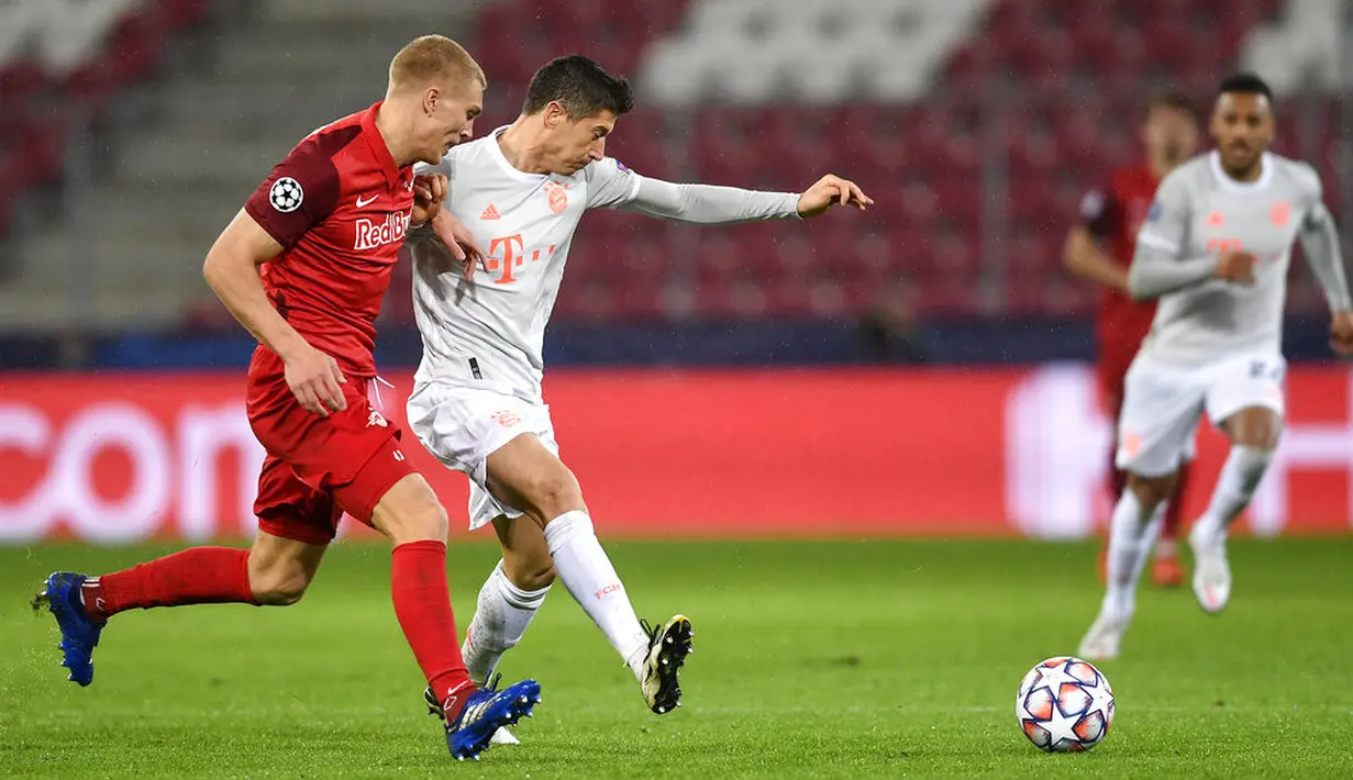Pemain RB Salzburg Rasmus Kristensen (kiri) berebut bola dengan pemain Bayern Munchen Robert Lewandowski pada pertandingan Grup A Liga Champions di Salzburg, Austria, Selasa (3/11/2020). Bayern Munchen menang 6-2. (AP Photo/Andreas Schaad)