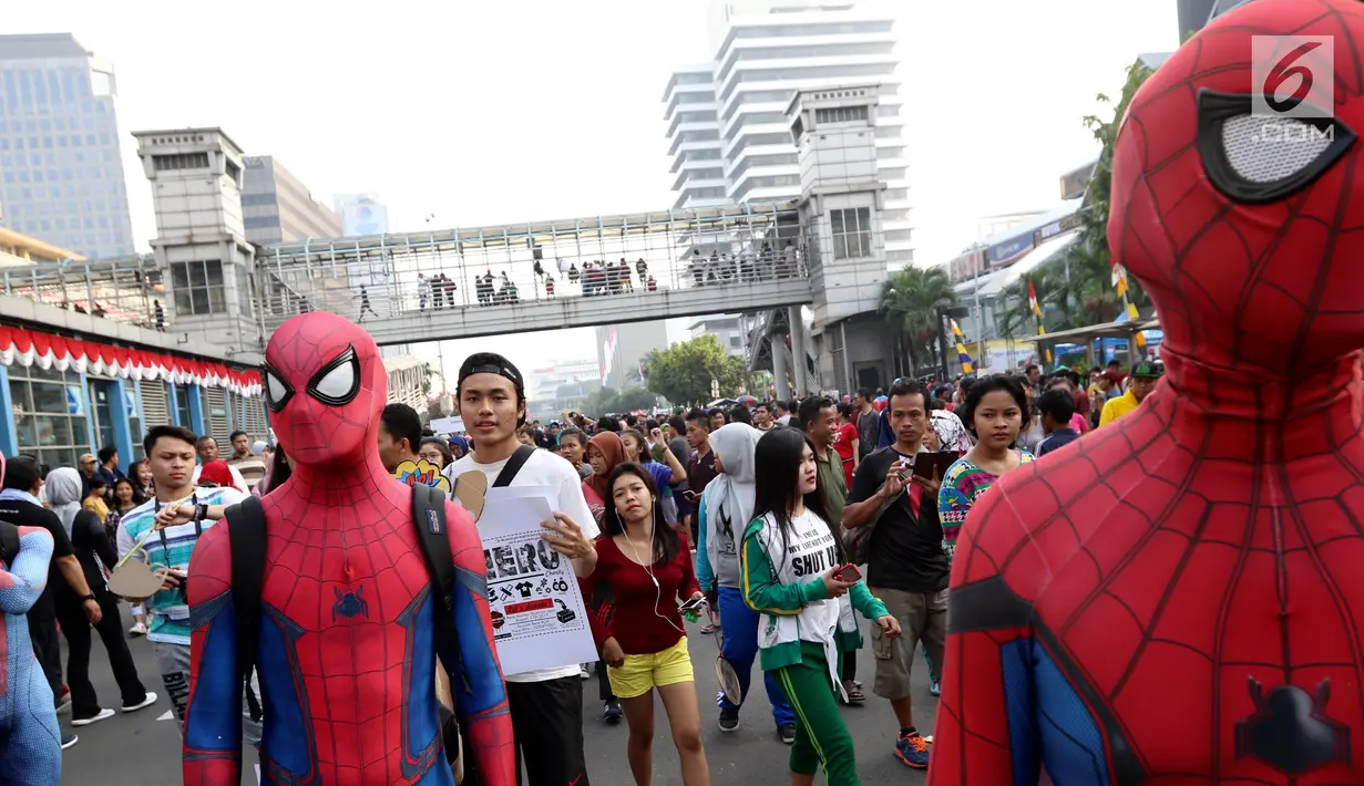 Sejumlah orang dengan kostum Spiderman menunggu warga untuk berswafoto di CFD Jalan MH Thamrin, Jakarta, Minggu (6/8). Kegiatan amal ini untuk membantu anak-anak yatim piatu. (Liputan6.com/Fery Pradolo)