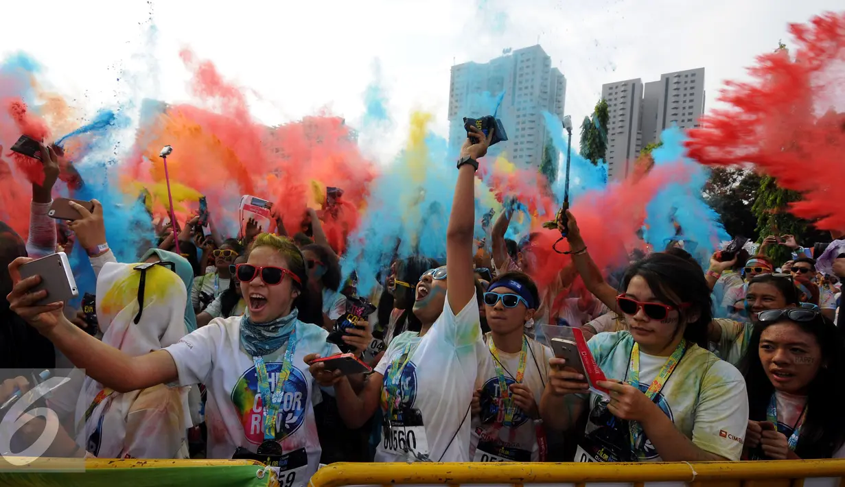 Beragam warna dilempar ke udara saat puncak gelaran Colour Run 2016 di Parkir Timur Senayan, Jakarta, Minggu (7/8). Tampak sejumlah muda mudi berpesta warna pada puncak event lari santai 5K Colour Run 2016. (Liputan6.com/Helmi Fithriansyah)