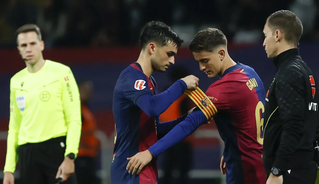 Pemain Barcelona, Gavi (kanan) menerima ban kapten saat menggantikan Pedri pada laga lanjutan Liga Spanyol 2024/2025 melawan Sevilla yang berlangsung di Estadi Olimpic Lluis Companys, Barcelona, Spanyol, Senin (21/10/2024) dini hari WIB. (AP Photo/Joan Monfort)
