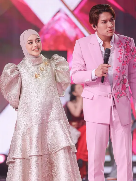 Dress yang memiliki aksen bros emas tiga bunga dipadukan dengan heels strap coklat. Tampak Lesti pun mengenakan stocking warna nude. [@lestikejora]