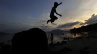 Seorang bocah bermain lompat dari atas batu di kawasan Pantai Besar, Larantuka, Flores Timur, NTT. (Antara)