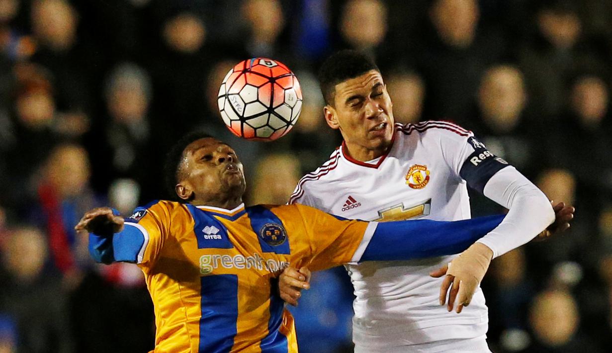 Pemain MU, Chris Smalling (kanan), duel dengan pemain Shrewsbury Town, Jean-Daniel Akpa Akpro, pada putaran kelima Piala FA di Stadion Greenhous Meadow, Shrewsbury, Selasa (23/2/2016) dini hari WIB. (Reuters/Andrew Yates)