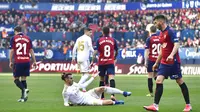 Penyerang Real Madrid, Gareth Bale, terjatuh saat berebut bola dengan pemain Osasuna pada laga La Liga di Stadion El Sadar, Minggu (9/2/2020). Real Madrid menang 4-1 atas Osasuna. (AP/Alvaro Barrientos)