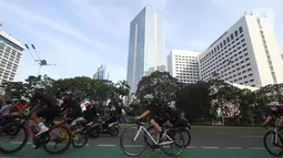 Pesepeda melintas Jalan Sudirman pada peluncuran jersey bersepeda Unlimited Hope hasil kokreasi Smartfren, Show The Monster dan Common Spot di Jakarta, Sabtu (27/3/2021). Hasil jersey bersepeda akan digunakan untuk pemberdayaan UMKM melalui Teman Kreasi Indonesia. (Liputan6.com/Pool)