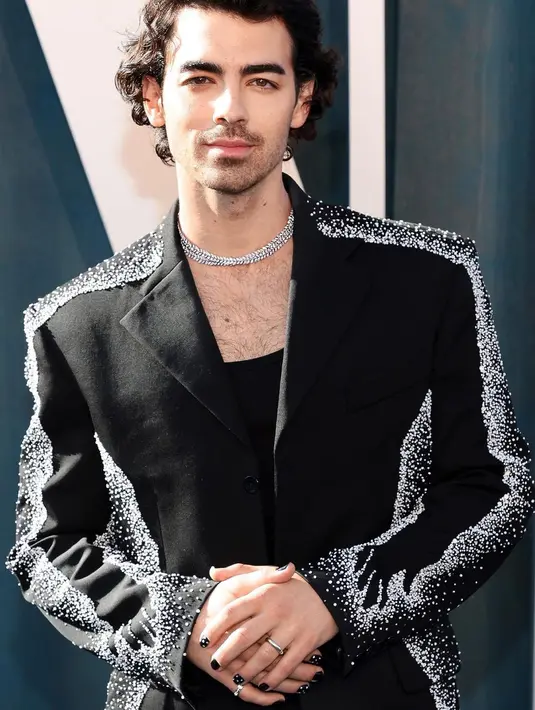 Joe Jonas mengenakan Custom Tiffany Victoria diamond vine necklace platinum 31’, cincin Tiffany Embrace Band, yang menyempurnakan tampilan super edgy miliknya.